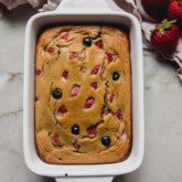Berry protein breakfast cake in a small ceramic baking dish.