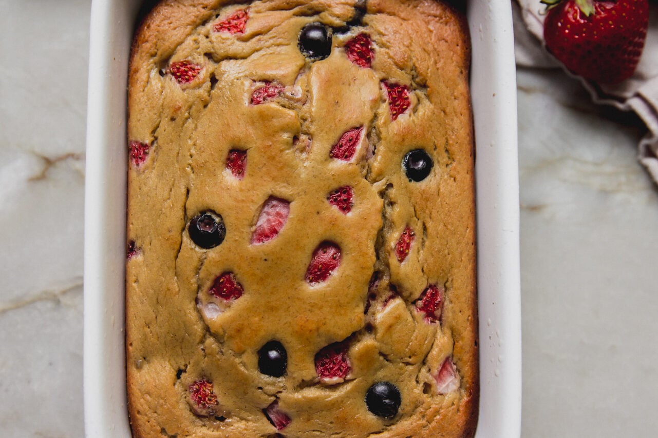 Berry protein breakfast cake in a small ceramic baking dish.