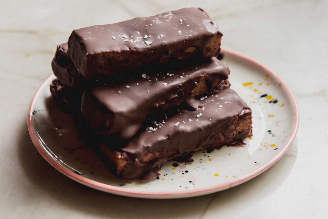 Brownie marshmallow protein bars stacked on top of each other on a plate.