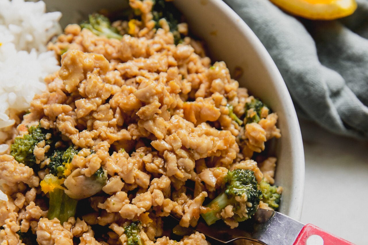cooked orange ground chicken in a bowl with rice. 