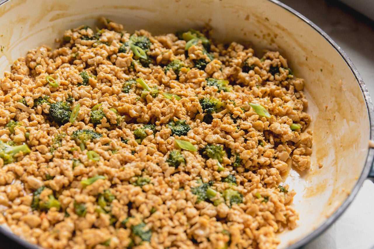 Cooked orange ground chicken in a pan. 