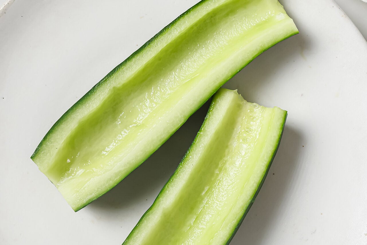 A cucumber sliced in half and hollowed out.