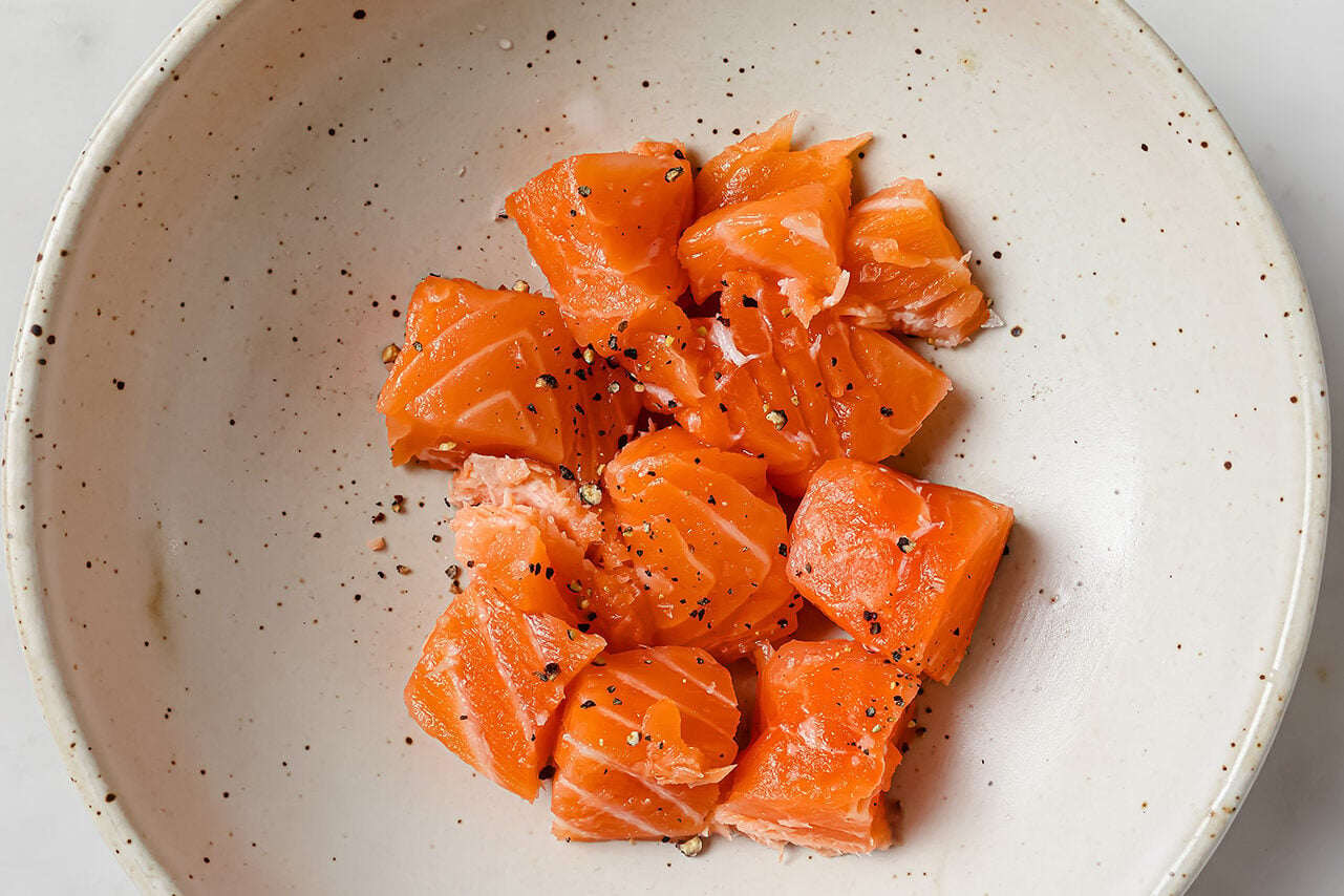 Diced salmon in a bowl with seasonings.