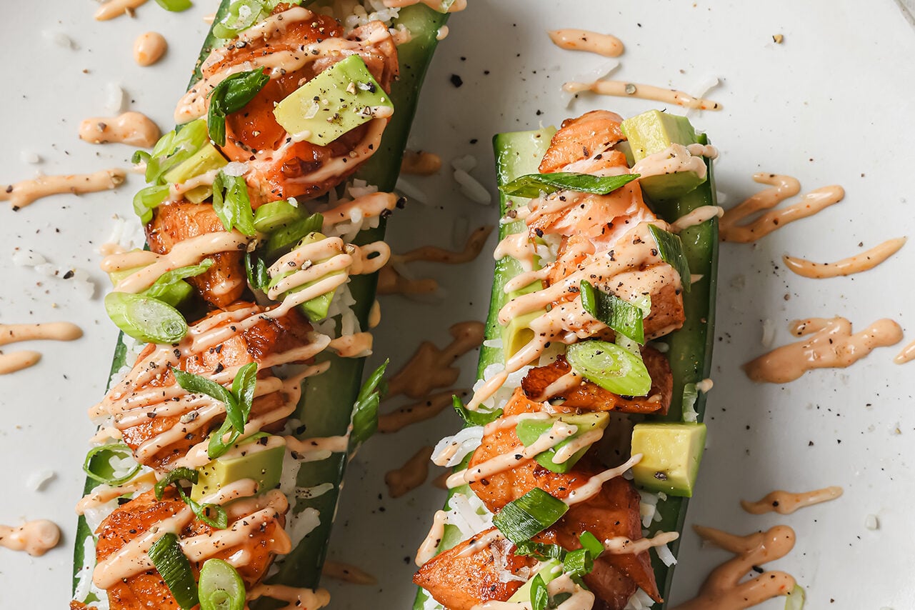 Salmon cucumber boats topped with avocado and a drizzle of spicy mayo.