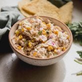 Street corn chicken salad in a bowl with tortilla chips in the background.
