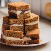 Ice cream cake sandwich bars stacked on top of each other on a pink plate.