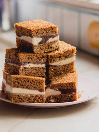 Ice cream cake sandwich bars stacked on top of each other on a pink plate.