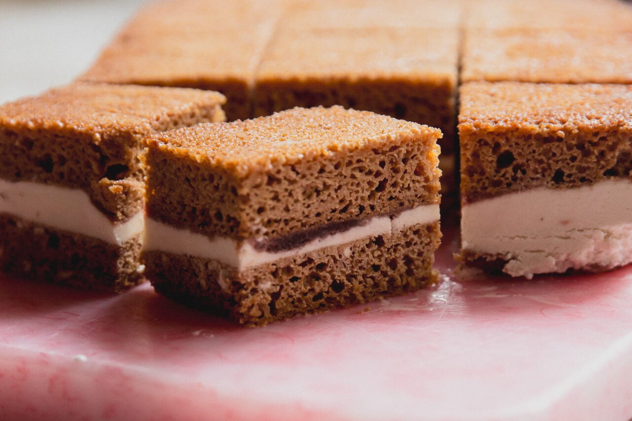 Ice cream cake sandwich bars sliced on a cutting board.