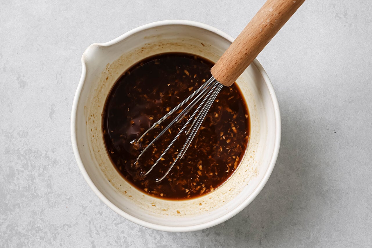 Mongolian chicken sauce in a bowl with a whisk.