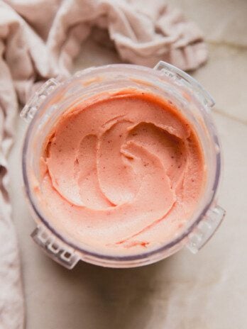 Peach ice cream in a ninja creami container.