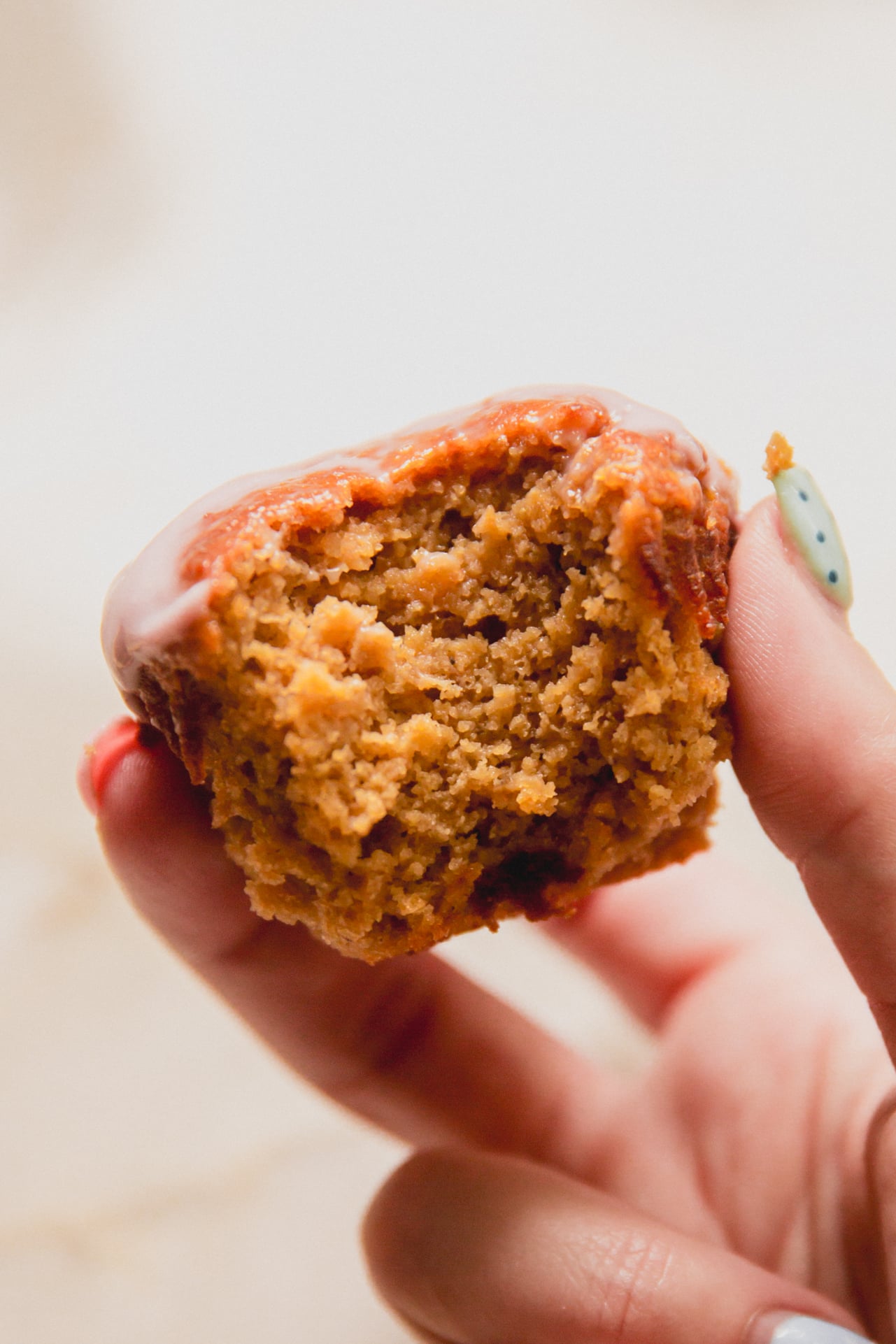 High protein muffin being held in a hand with a bite taken out of it.