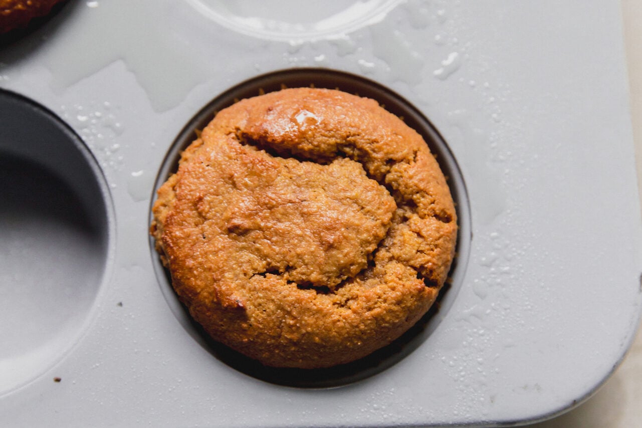 A muffin tin with a freshly baking high protein muffin in it.