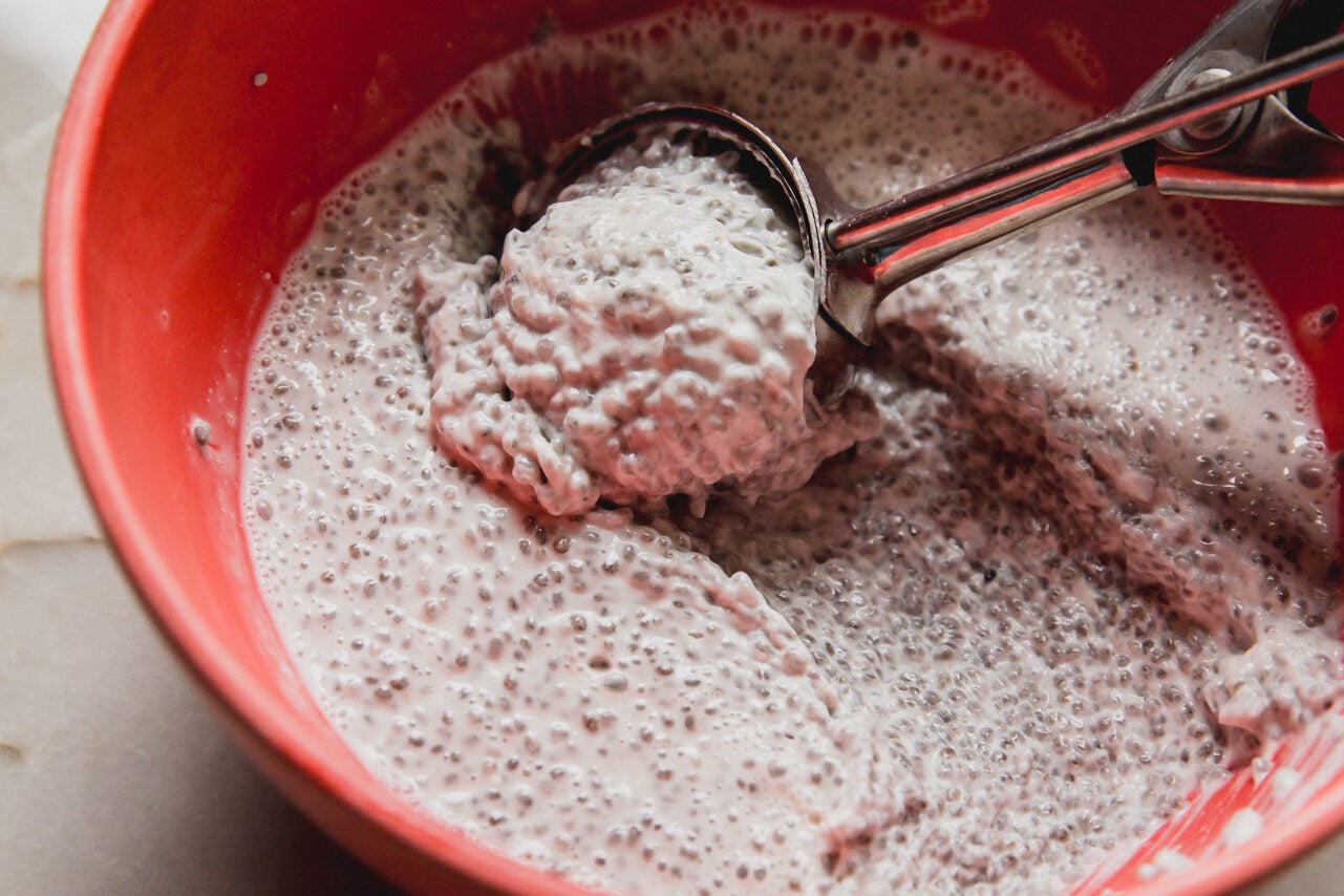 A red bowl filled with chia seed mixture after solidifying in the fridge.
