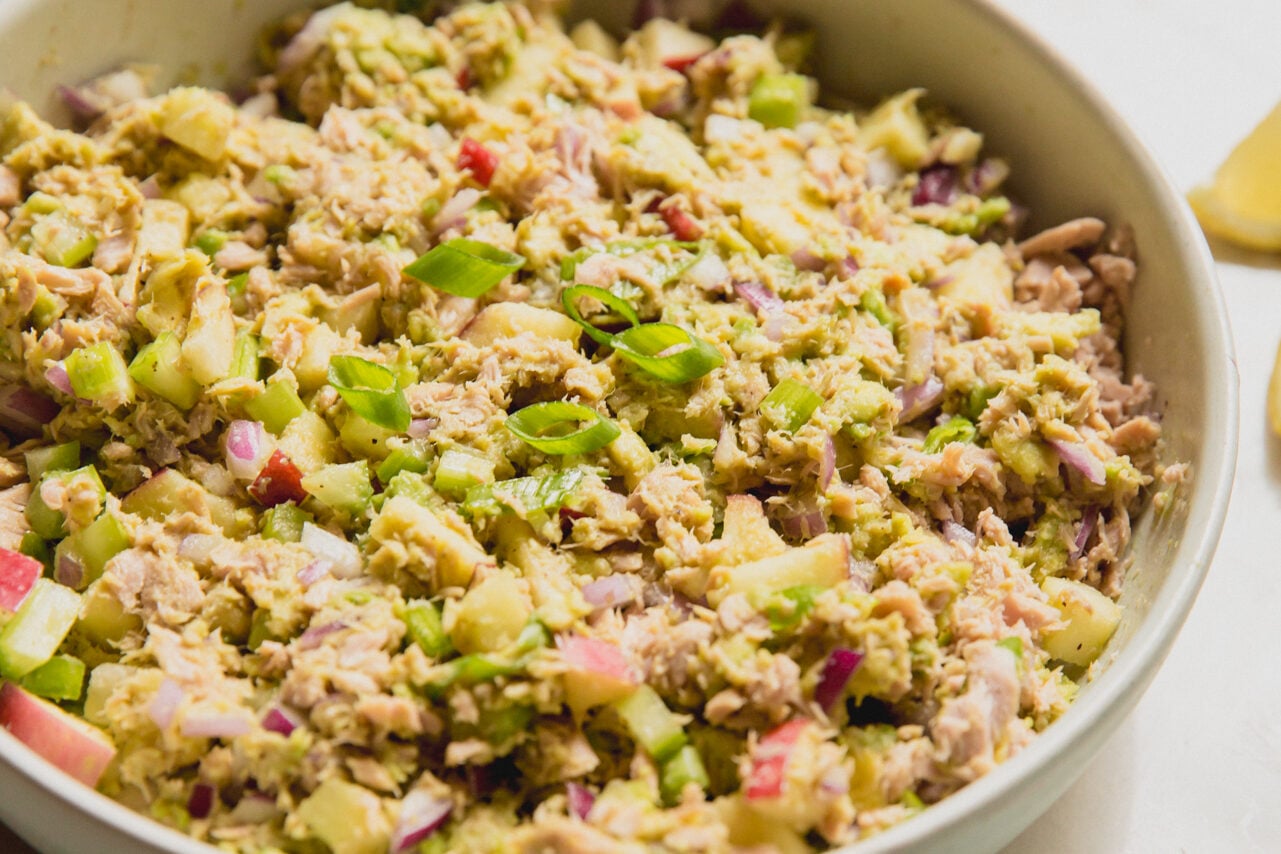 Avocado tuna salad in a bowl topped with green onion