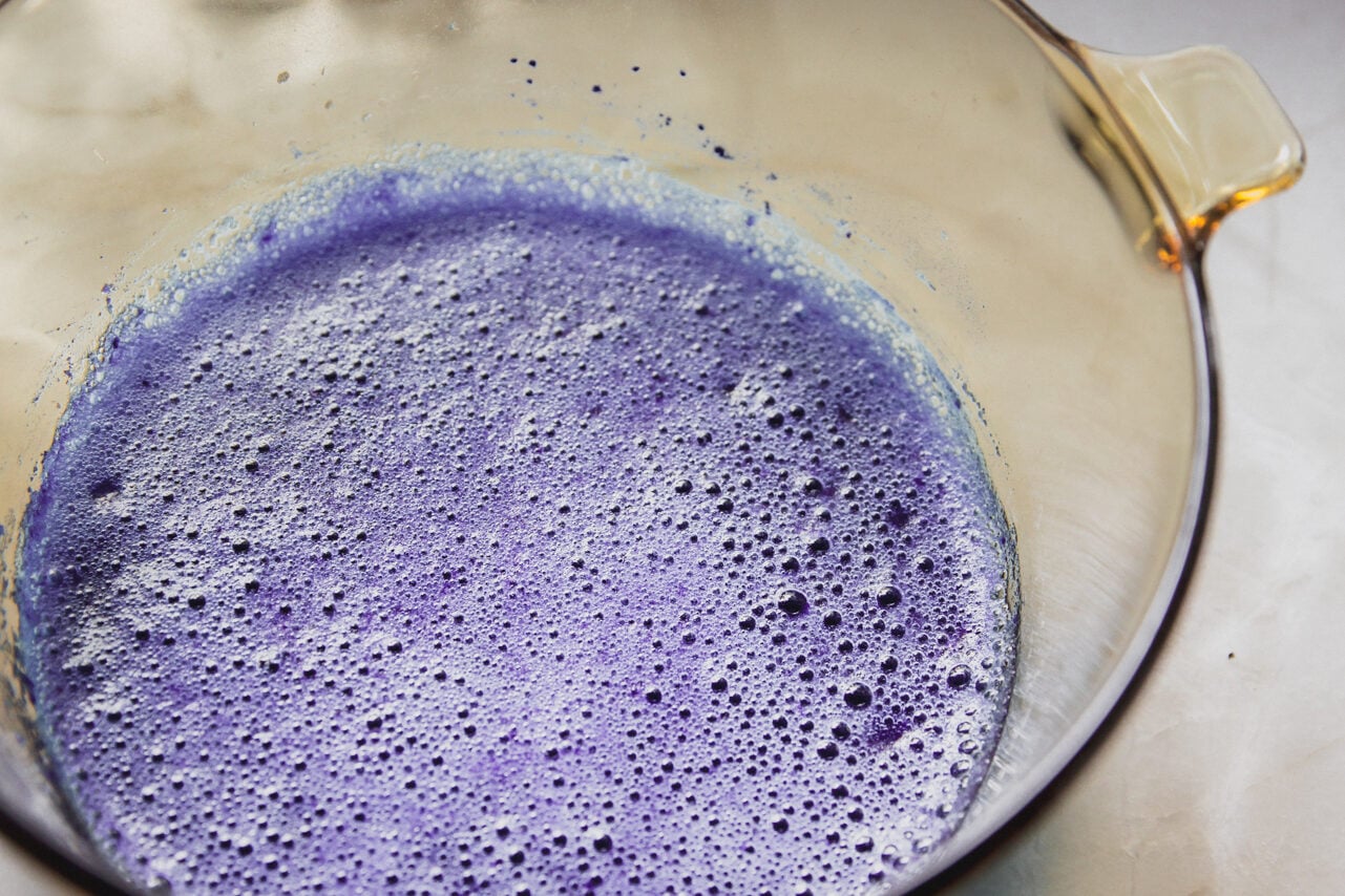 A glass bowl of blue raspberry mixture with gelatin.