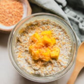 Mango chia pudding in a cup topped with diced mango and toasted coconut