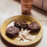 Three coconut froyo bars on a plate with yogurt in the background