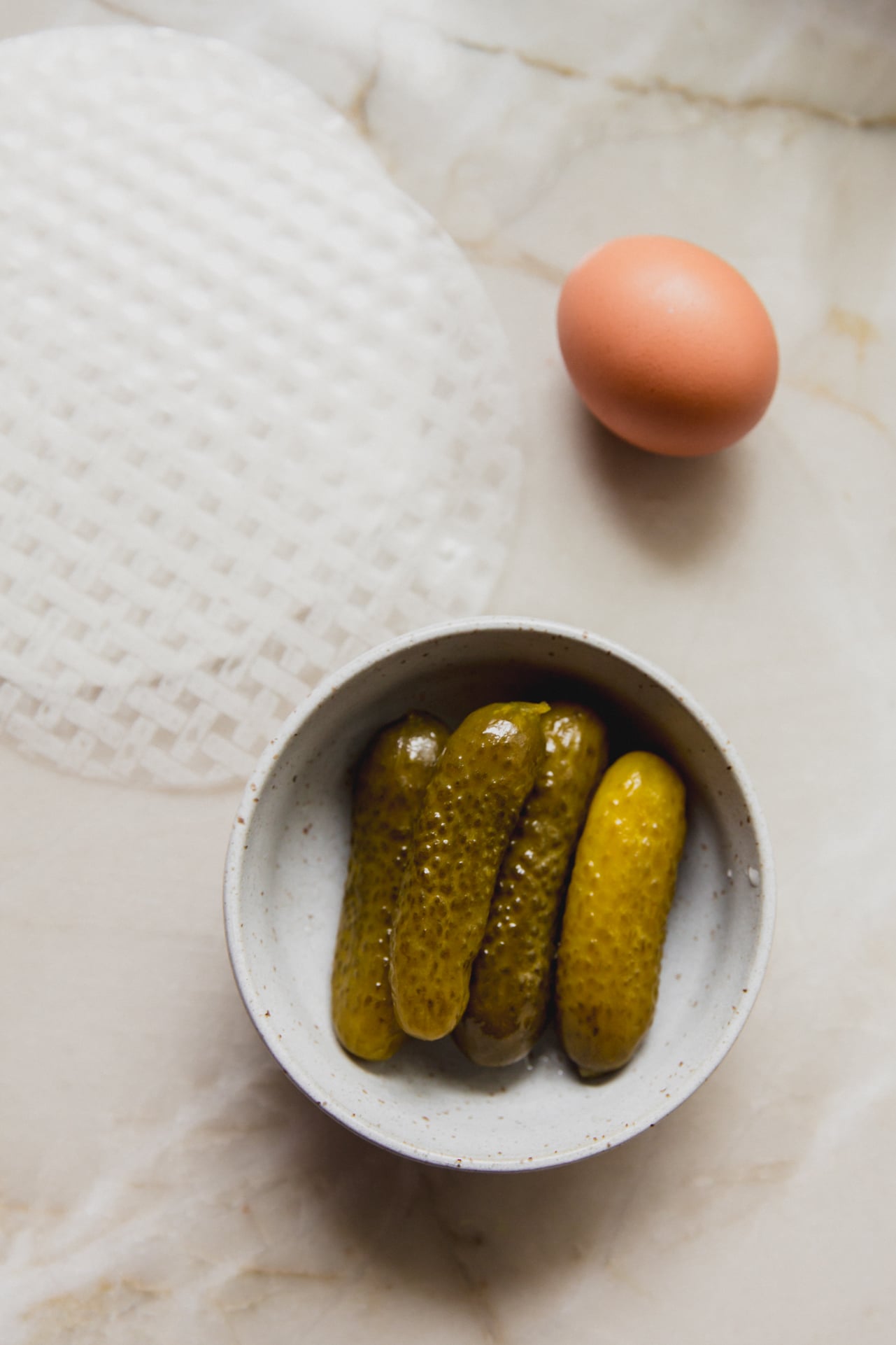 Pickles, rice paper and egg on a marble conter