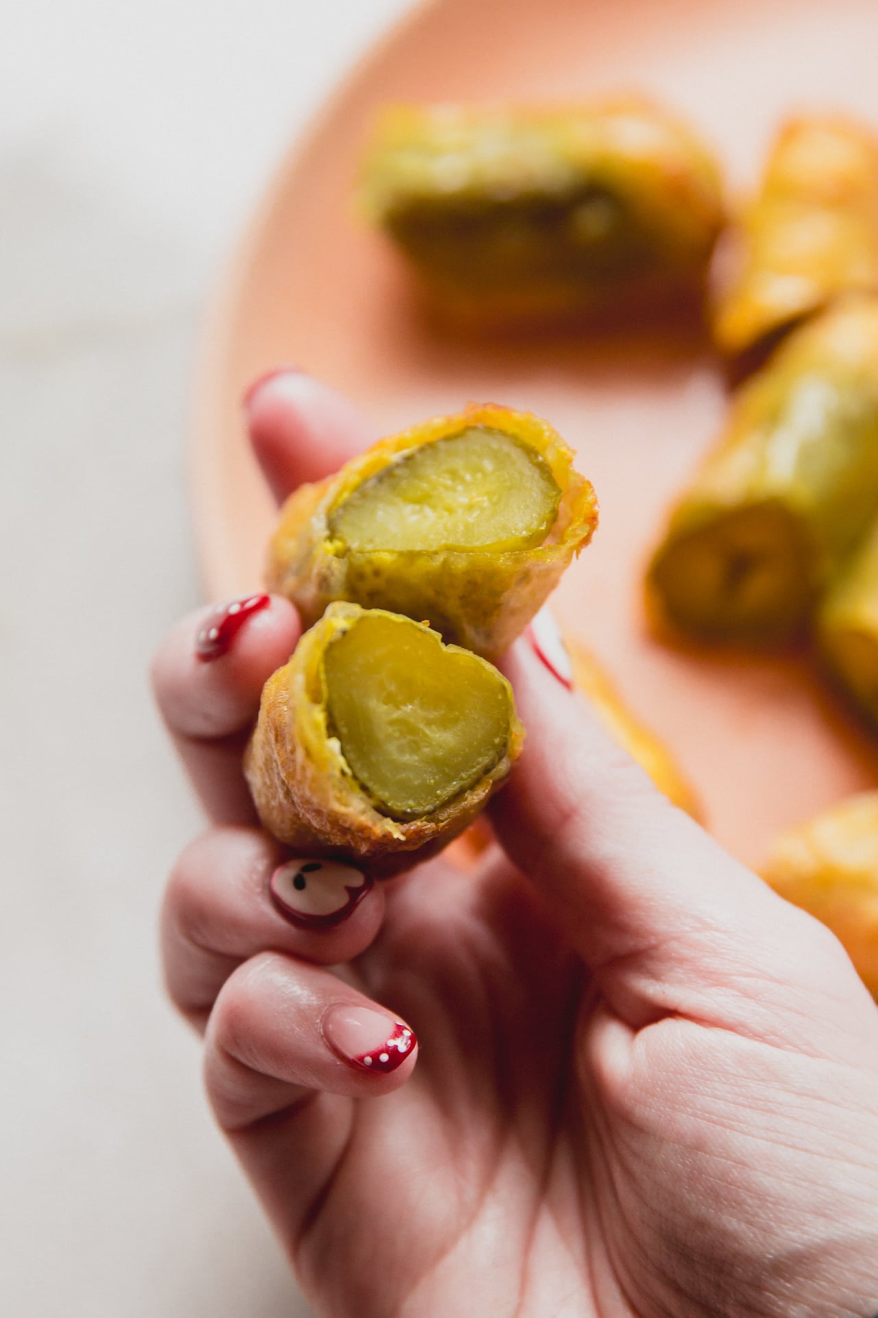 Rice paper fried pickles cut in half and being held