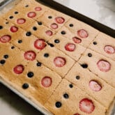 Sheet pan pancakes topped with berries on a large sheet pan