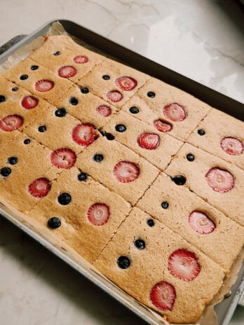 Sheet pan pancakes topped with berries on a large sheet pan