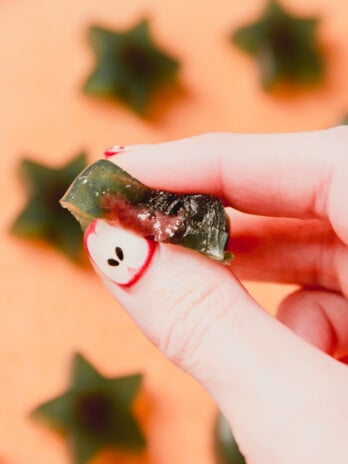 Sour apple gusher with the filling being squeezed out