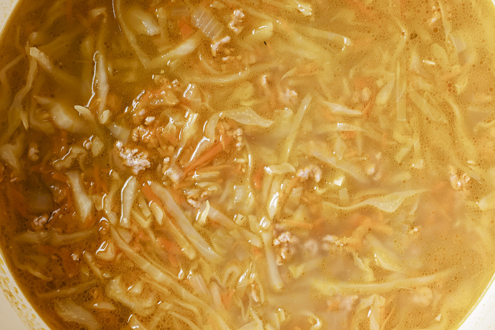 Egg roll soup in a large cast iron pot.
