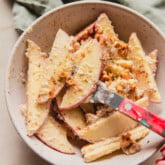 Sliced apple pretzel salad in a bowl with a red fork