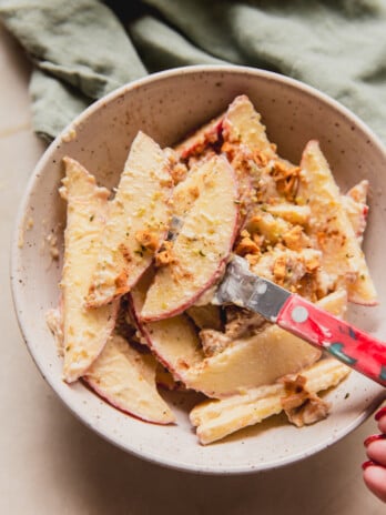 Sliced apple pretzel salad in a bowl with a red fork