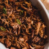 Honey ginger pork shredded in a white baking dish.