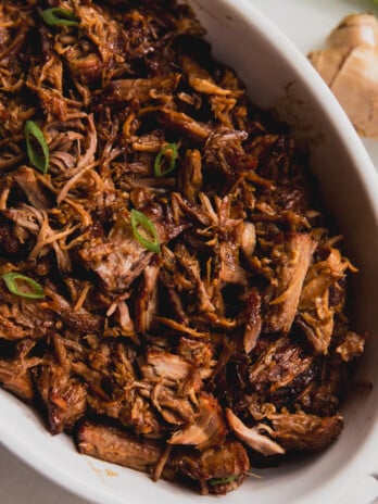 Honey ginger pork shredded in a white baking dish.